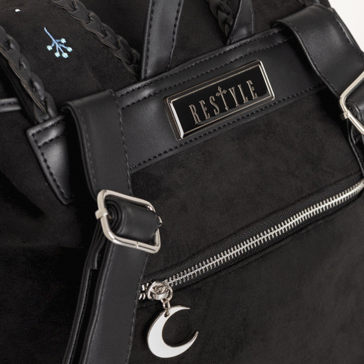Mochila de ante con detalles trenzados en cuero y bordado en tonos fríos de polillas y lunas inspirado en un bosque mágico nocturno vista detalle posterior