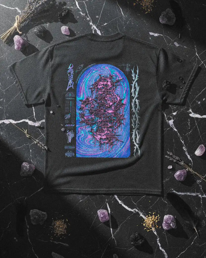 camiseta biohazard de halfcurve apoyada sobre encimera de mármol con detalles esotéricos al rededor