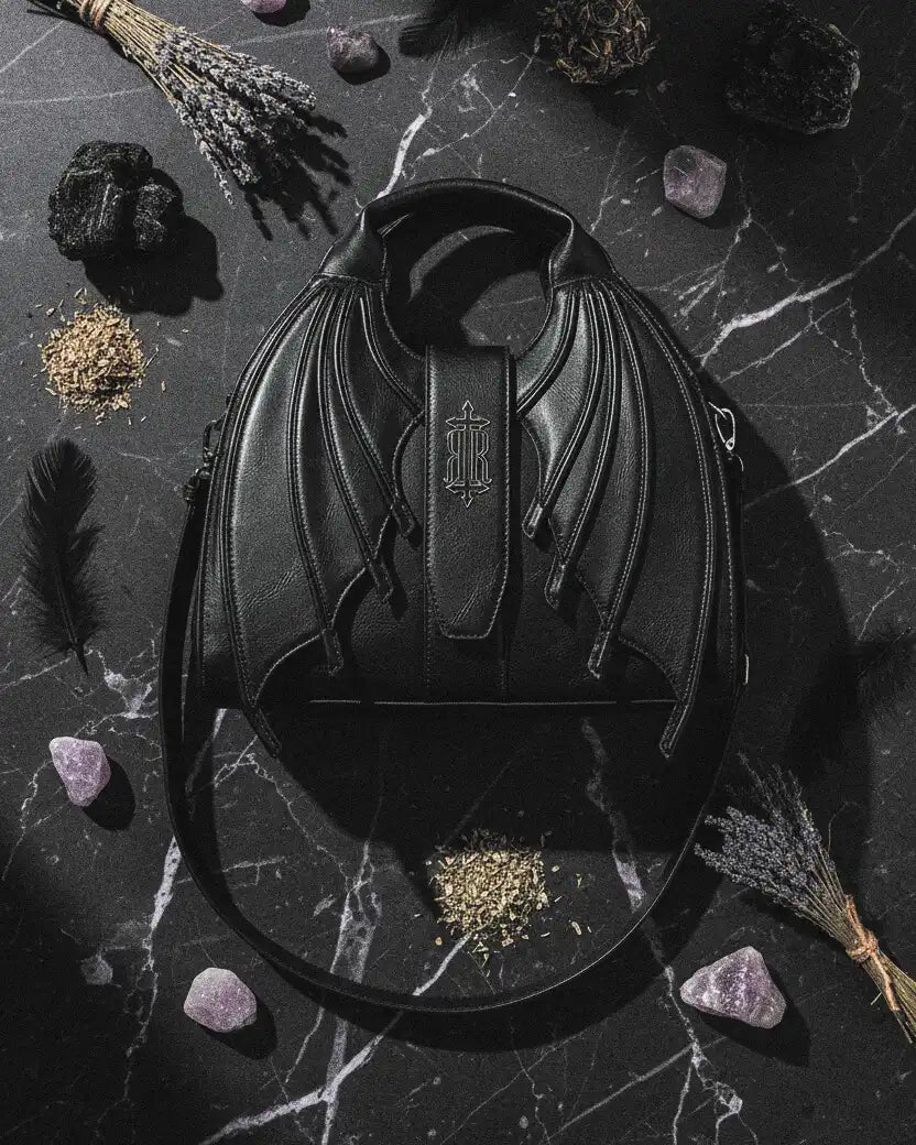 bolso succubus de restyle apoyado sobre una mesa de mármol con detalles esotéricos al rededor