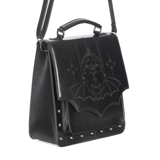Mochila convertible a bolso bandolera o bolso de mano con bordado y solapa en forma de murciélago y remaches metálicos en la parte frontal vista ángulo con correa