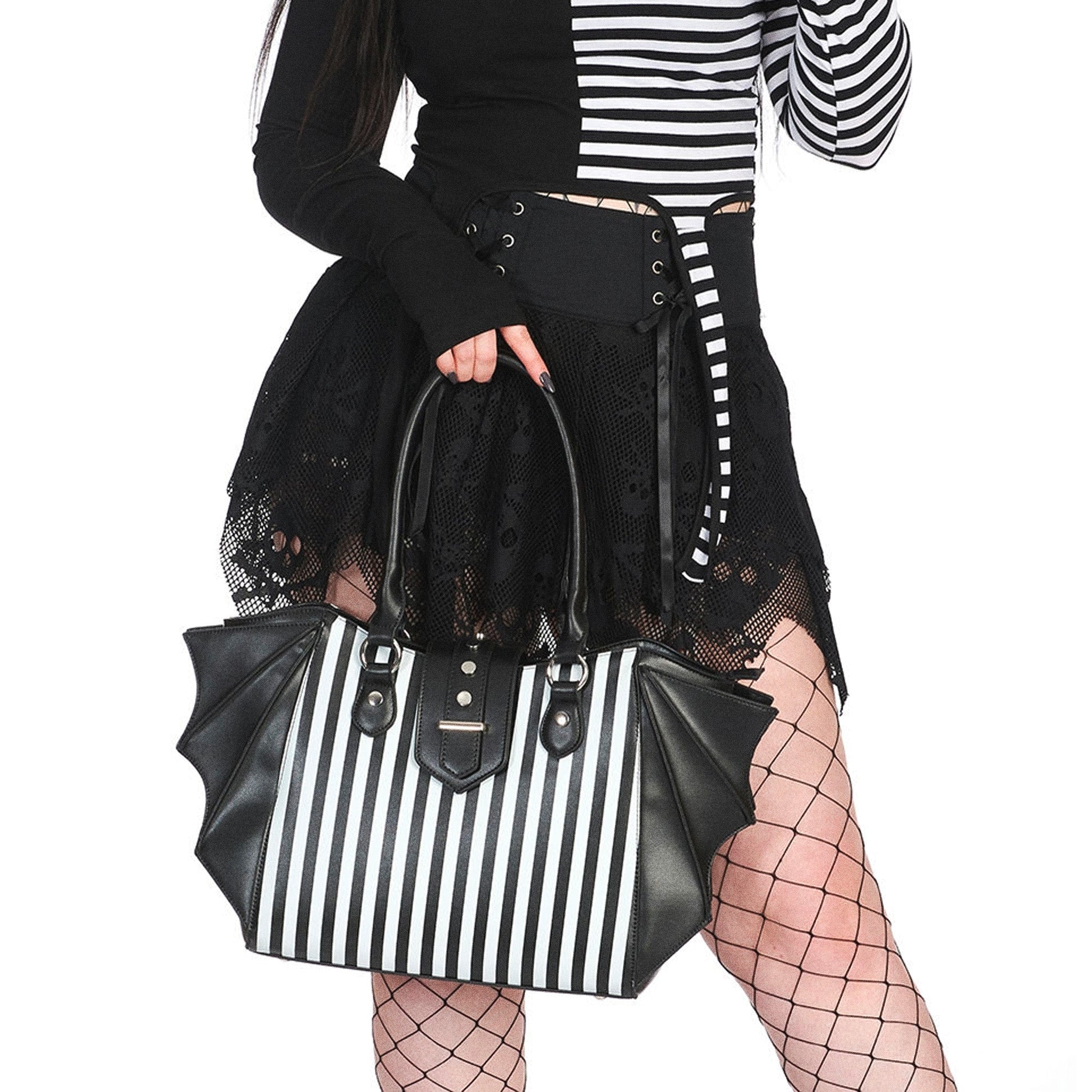 Bolso shopper grande con estampado de rayas verticales en el frontal, adornos en forma de alas de murciélago en los laterales y detalle metálico en el cierre central vista en modelo