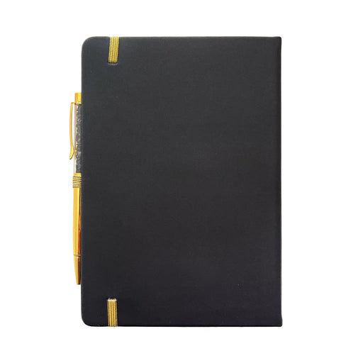 Parte posterior de la libreta lisa negra donde se ve el bolígrafo acoplado y la cinta que cierra verticalmente la libreta.