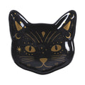 Plato con forma de cara de gato negro con detalles en color dorado estilo witchy sobre fondo blanco.