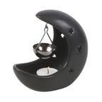 Quemador de aceite en forma de luna creciente con estrellas cut out en color negro con colgante metálico negro para poner aceite vista ángulo sobre fondo blanco con vela dentro. 