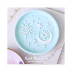 Bandeja para joyería en tono azul pastel con relieve de sol, luna y estrellas en color blanco estética whimsical y aesthetic vista de packaging sobre fondo blanco.