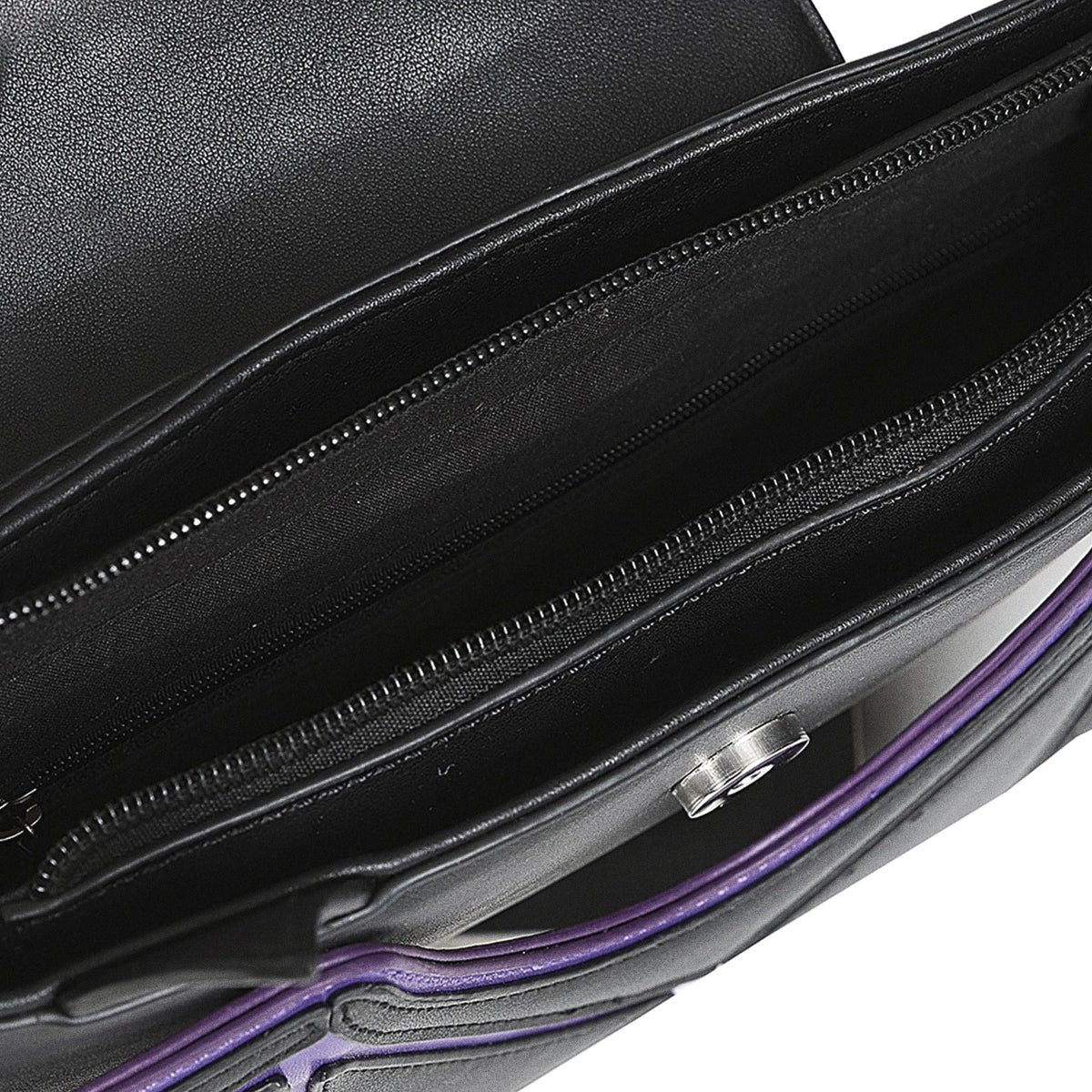 Interior del bolso gótico mostrando los compartimentos forrados en tela negra y los bolsillos con cremallera.