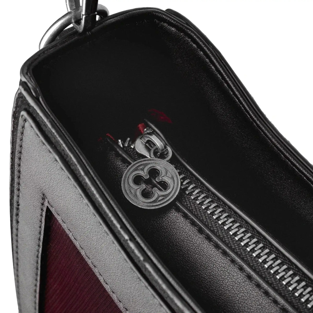 Bolso bandolera negro con diseño rígido en forma de escudo inspirado en las catedrales y la arquitectura medieval con detalles en terciopelo burdeos modelo Claretia de Restyle vista detalle cierre principal bolso