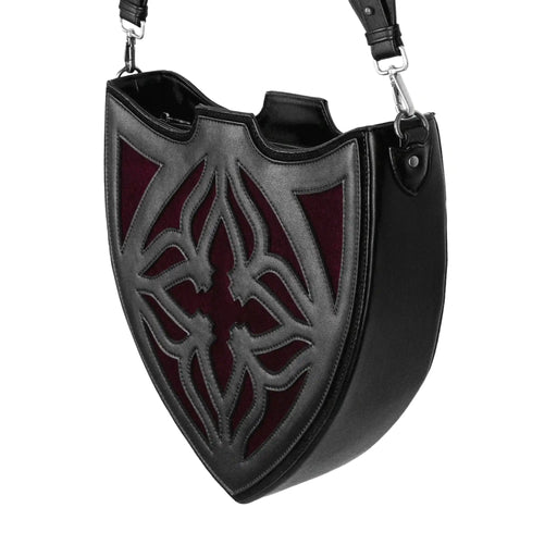 Bolso bandolera negro con diseño rígido en forma de escudo inspirado en las catedrales y la arquitectura medieval con detalles en terciopelo burdeos modelo Claretia de Restyle vista ángulo