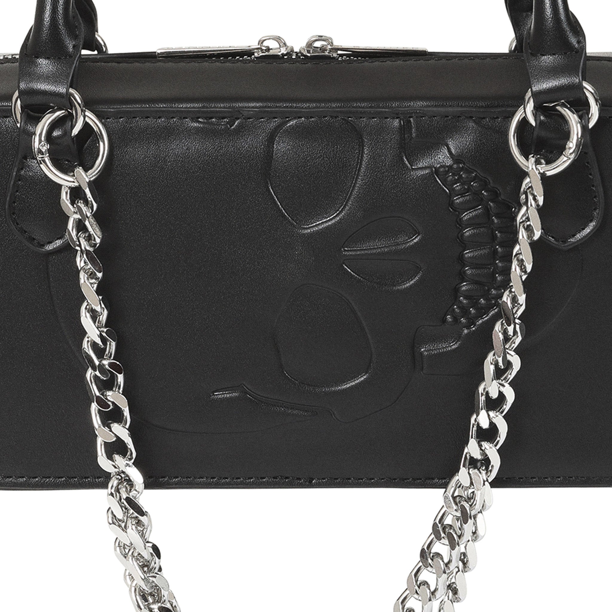 Primer plano de la calavera grabada en relieve sobre la superficie del bolso gótico negro.