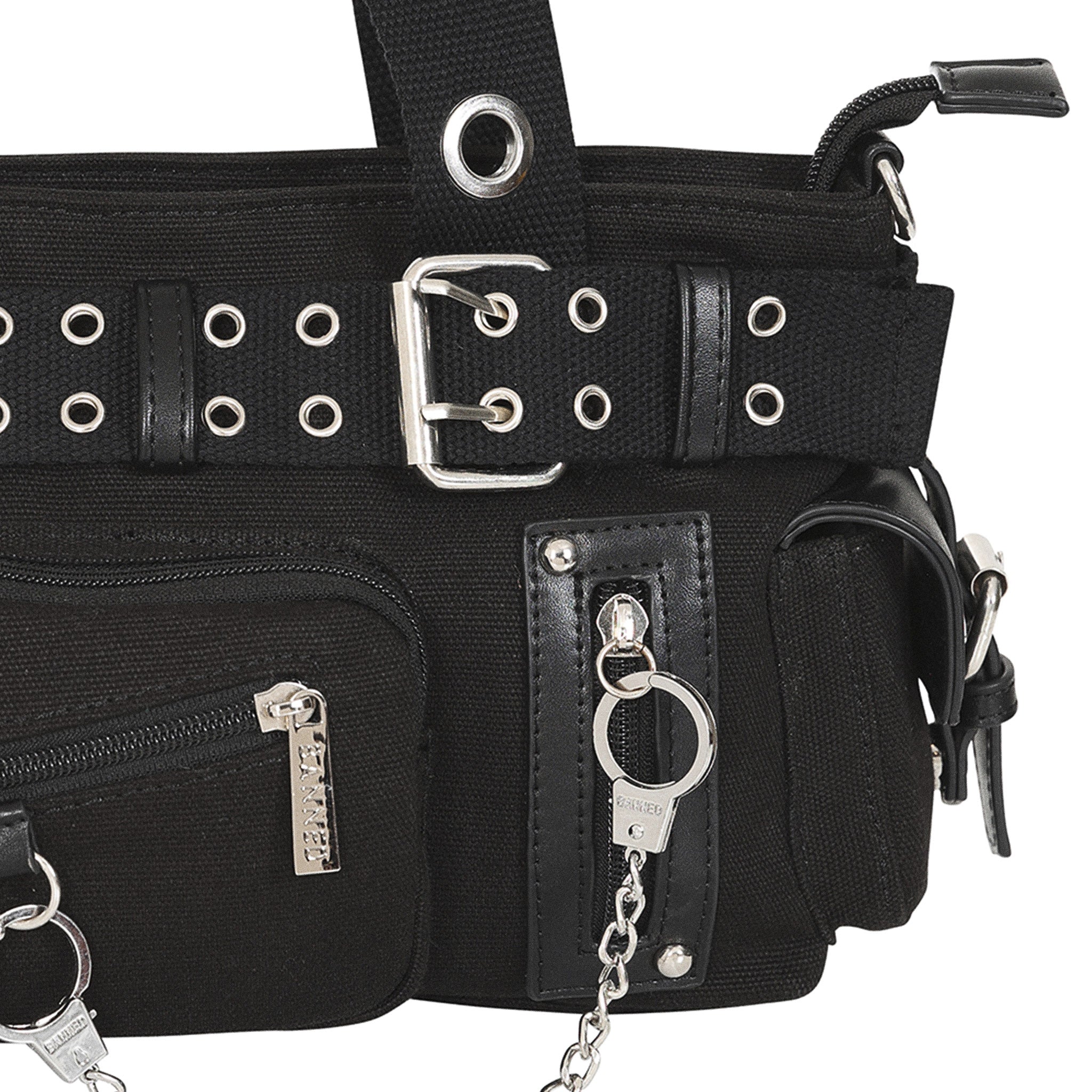 Primer plano de los detalles del bolso: hebilla del cinturón, bolsillos frontales y la cadena colgando.