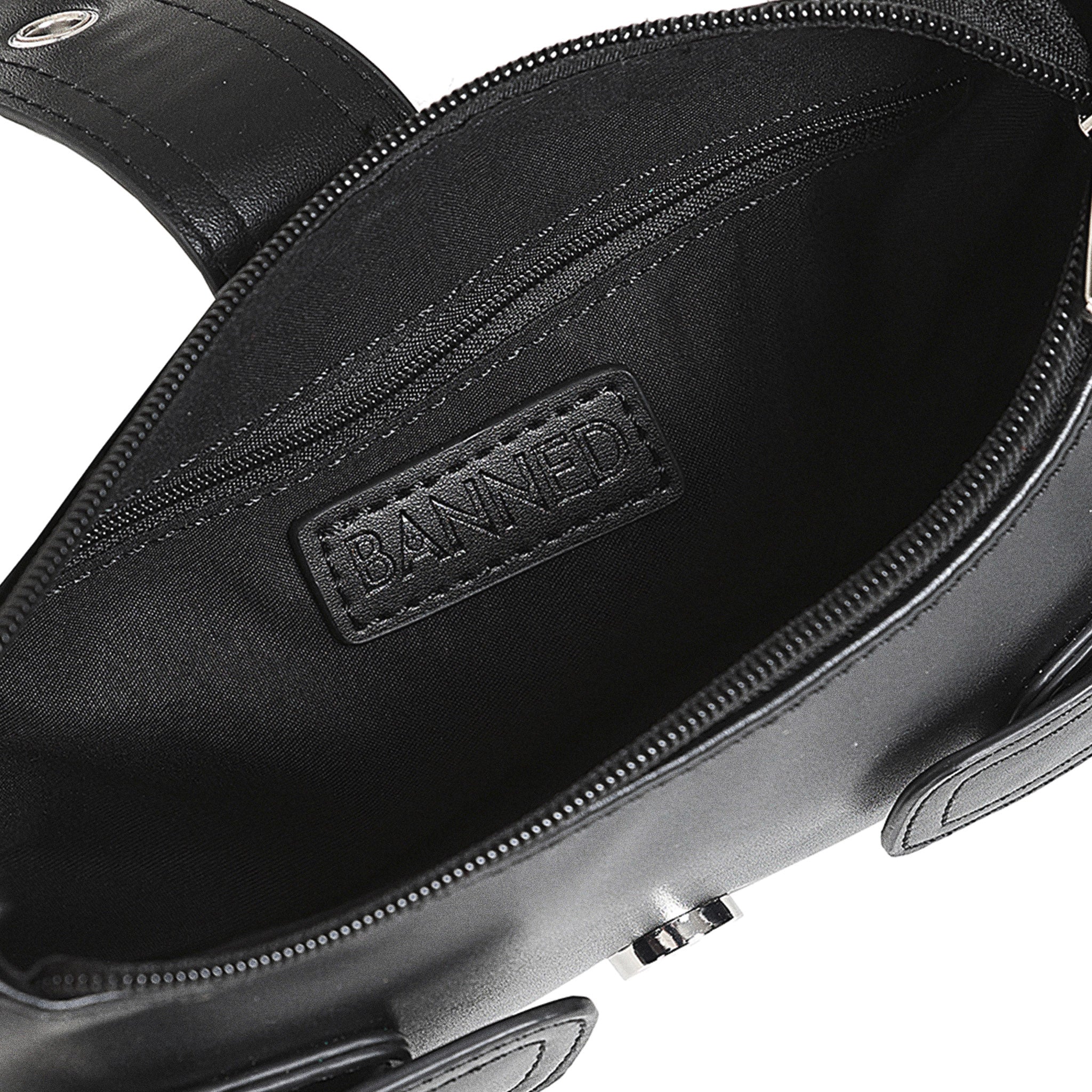 Interior del bolso baguette mostrando el forro negro y el compartimento principal con cremallera.