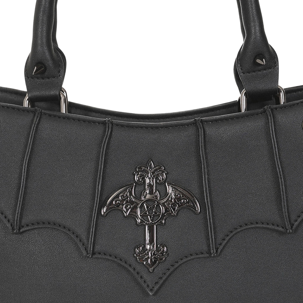  Close-up of the metal ornament: a cross with bat wings and a pentagram center