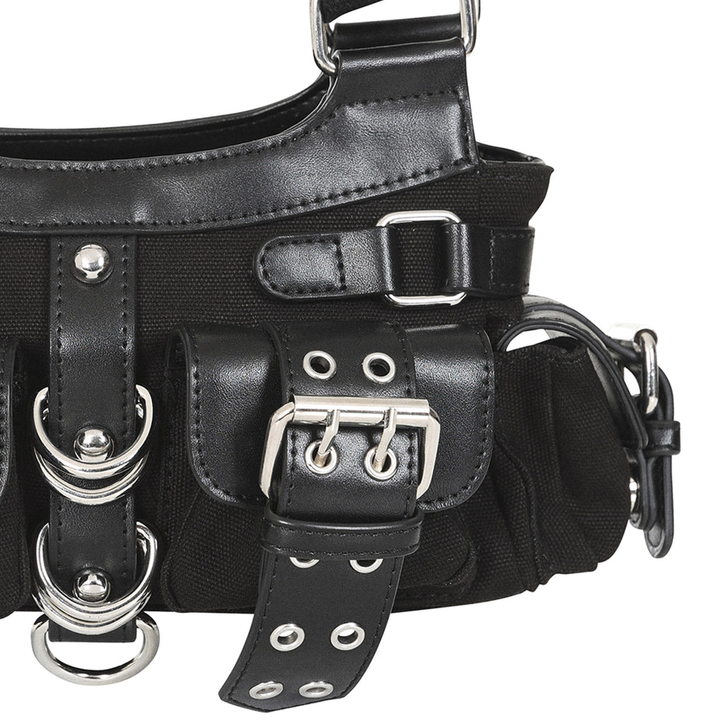 Primer plano del bolsillo frontal del bolso, mostrando el detalle de la hebilla y los anillas metálicas.