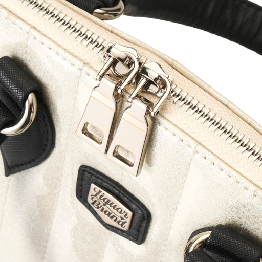 Detalle de la cremallera metálica con doble tirador sobre el cuerpo blanco brillante del bolso Lil' Rocket.