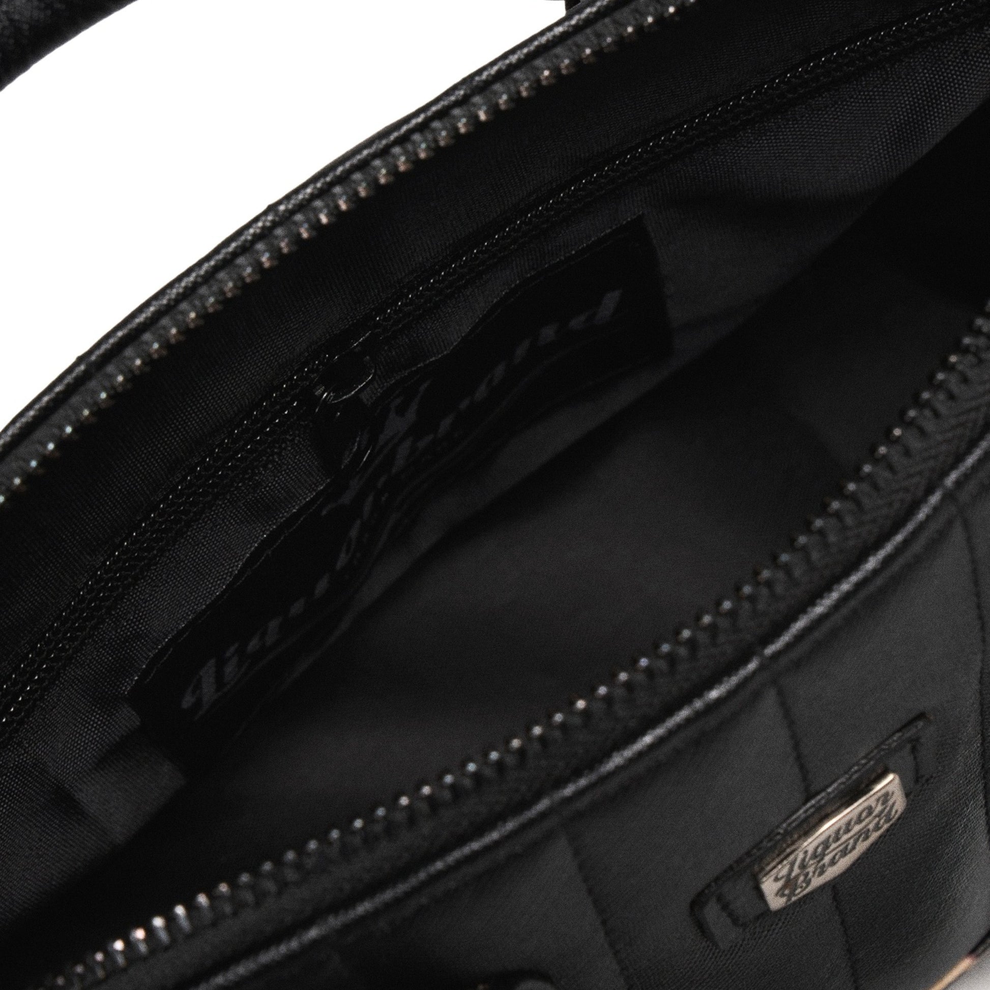 Interior del bolso Lil' Rocket con el forro negro y el bolsillo lateral con cremallera.