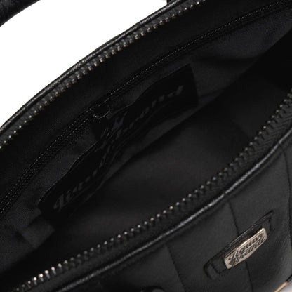 Interior del bolso Lil' Rocket con el forro negro y el bolsillo lateral con cremallera.