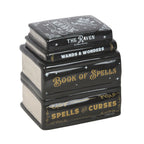 Quemador de aceite y de cera en forma de libros apilados estilo witchy gótico vista ángulo sobre fondo blanco.
