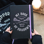Libreta sujetada por unas manos con un fondo decorativo.