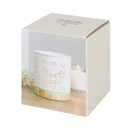 Quemador de aceites esenciales y calentador de cera con diseño de mariposa calada en blanco y base de madera vista packaging sobre fondo blanco.