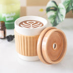 Quemador de aceites esenciales con forma de taza de café take away aesthetic vista fontal con tapa quitada sobre escritorio con decoración alrededor.