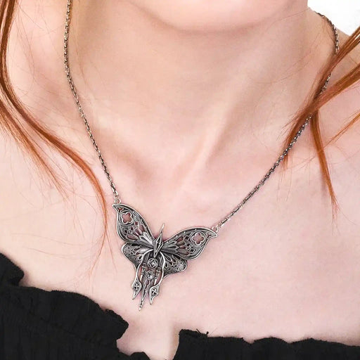 Collar estilo gótico whimsigoth con polilla calada inspirada en detalles arquitectónicos de las catedrales fabricada en latón con un baño de plata de ley vista en el cuello de la modelo