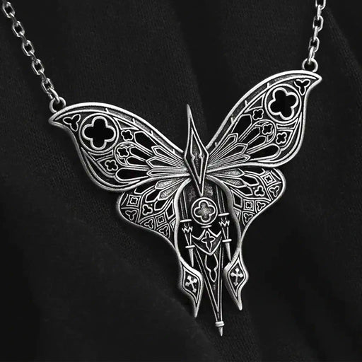 Collar estilo gótico whimsigoth con polilla calada inspirada en detalles arquitectónicos de las catedrales fabricada en latón con un baño de plata de ley vista de detalle del colgante en ángulo sobre fondo negro
