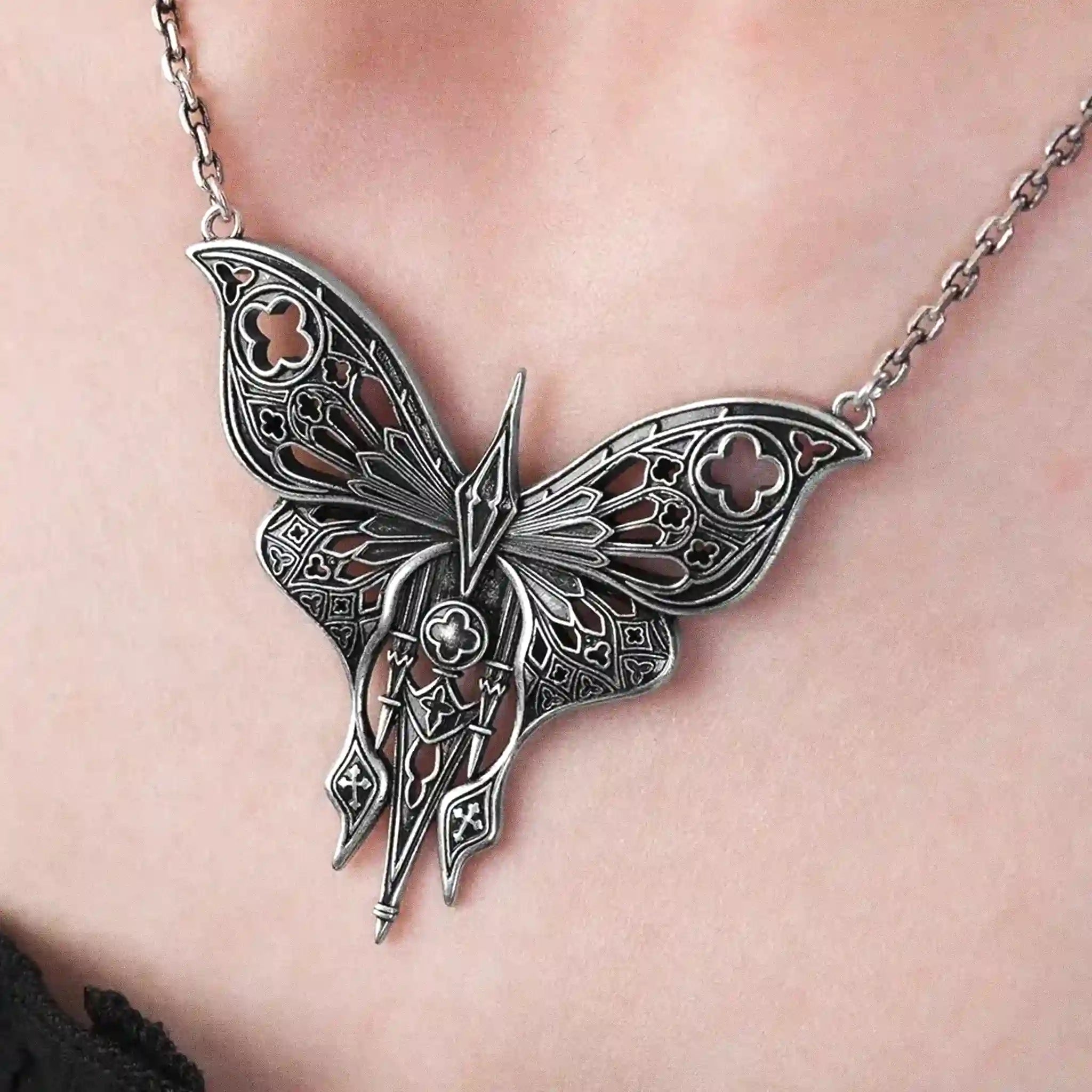 Collar estilo gótico whimsigoth con polilla calada inspirada en detalles arquitectónicos de las catedrales fabricada en latón con un baño de plata de ley vista de detalle del colgante sobre la modelo