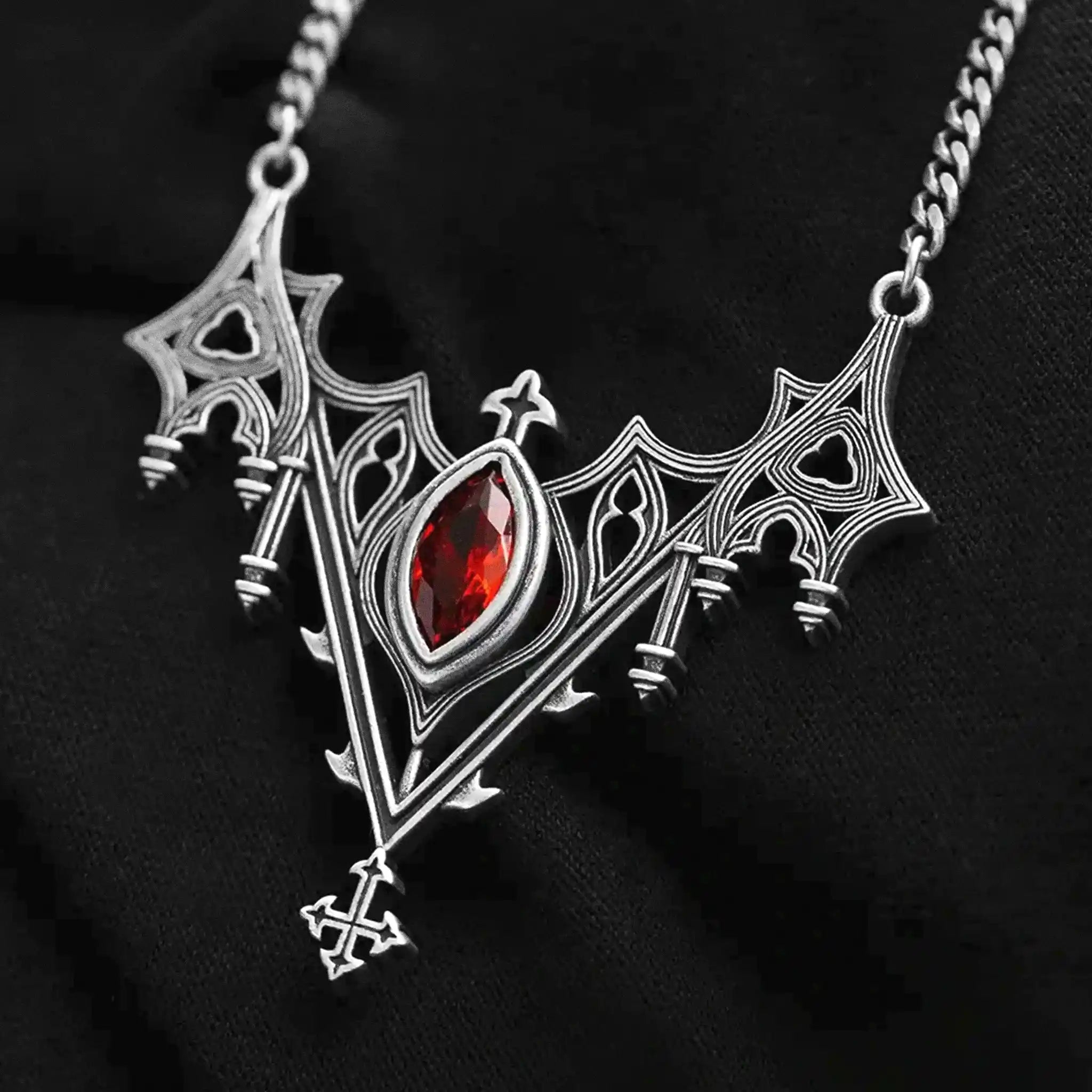 Collar con silueta de murciélago creada por detalles inspirados en catedrales góticas y piedra roja central engarzada fabricado en latón y plata de ley de Restyle vista detalle colgante sobre fondo negro