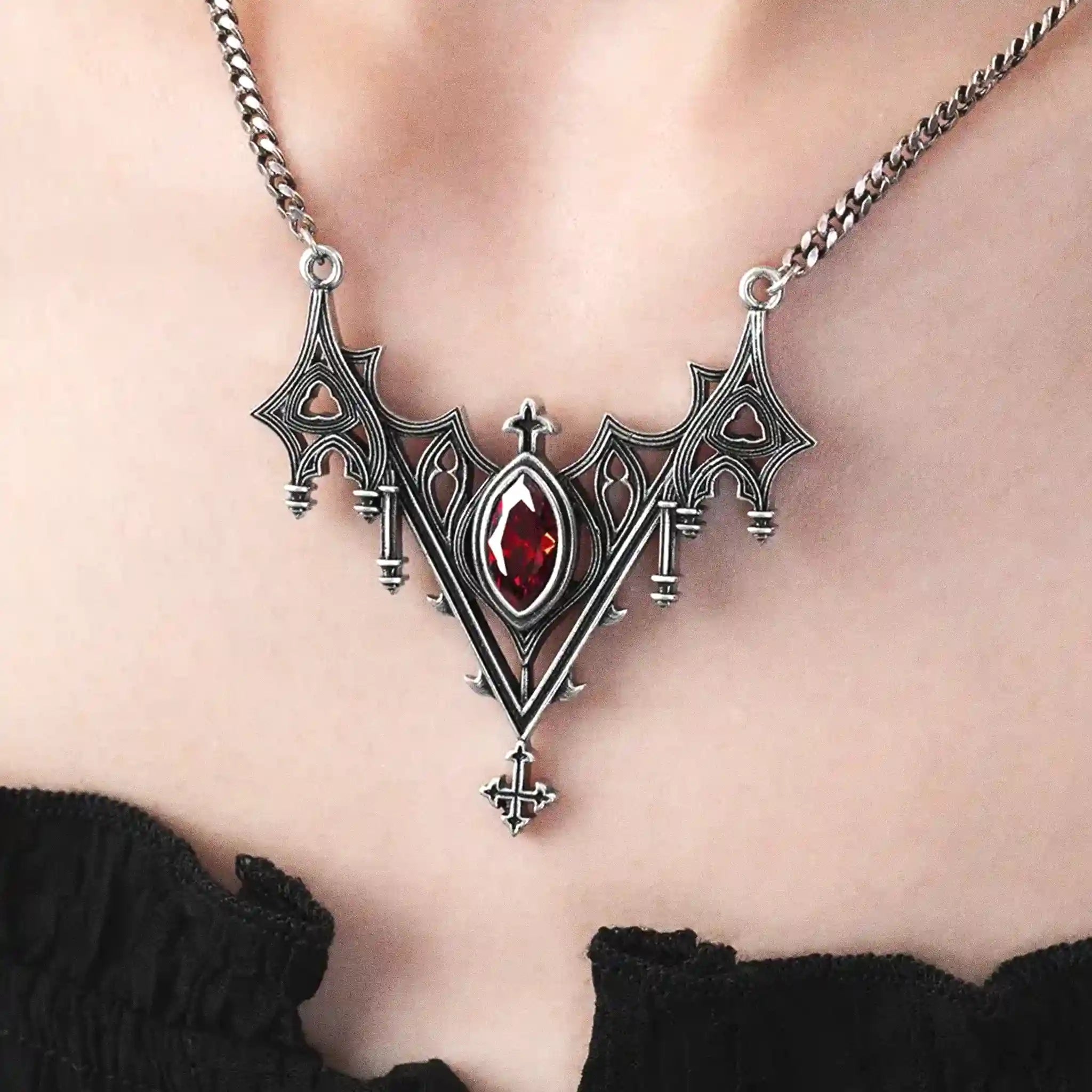 Collar con silueta de murciélago creada por detalles inspirados en catedrales góticas y piedra roja central engarzada fabricado en latón y plata de ley de Restyle vista detalle colgante en la modelo