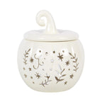 Quemador de aceites esenciales y calentador de cera con diseño de calabaza calado con motivos otoñales en blanco roto vista frontal sobre fondo blanco.