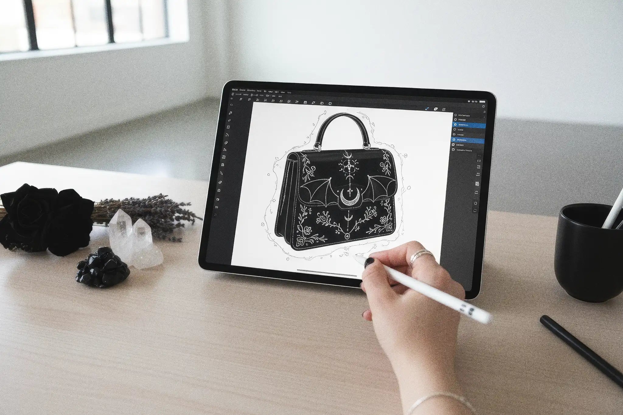 Diseñando un bolso en una tablet sobre una mesa con decoración esotérica en la oficina de GloryTheShop