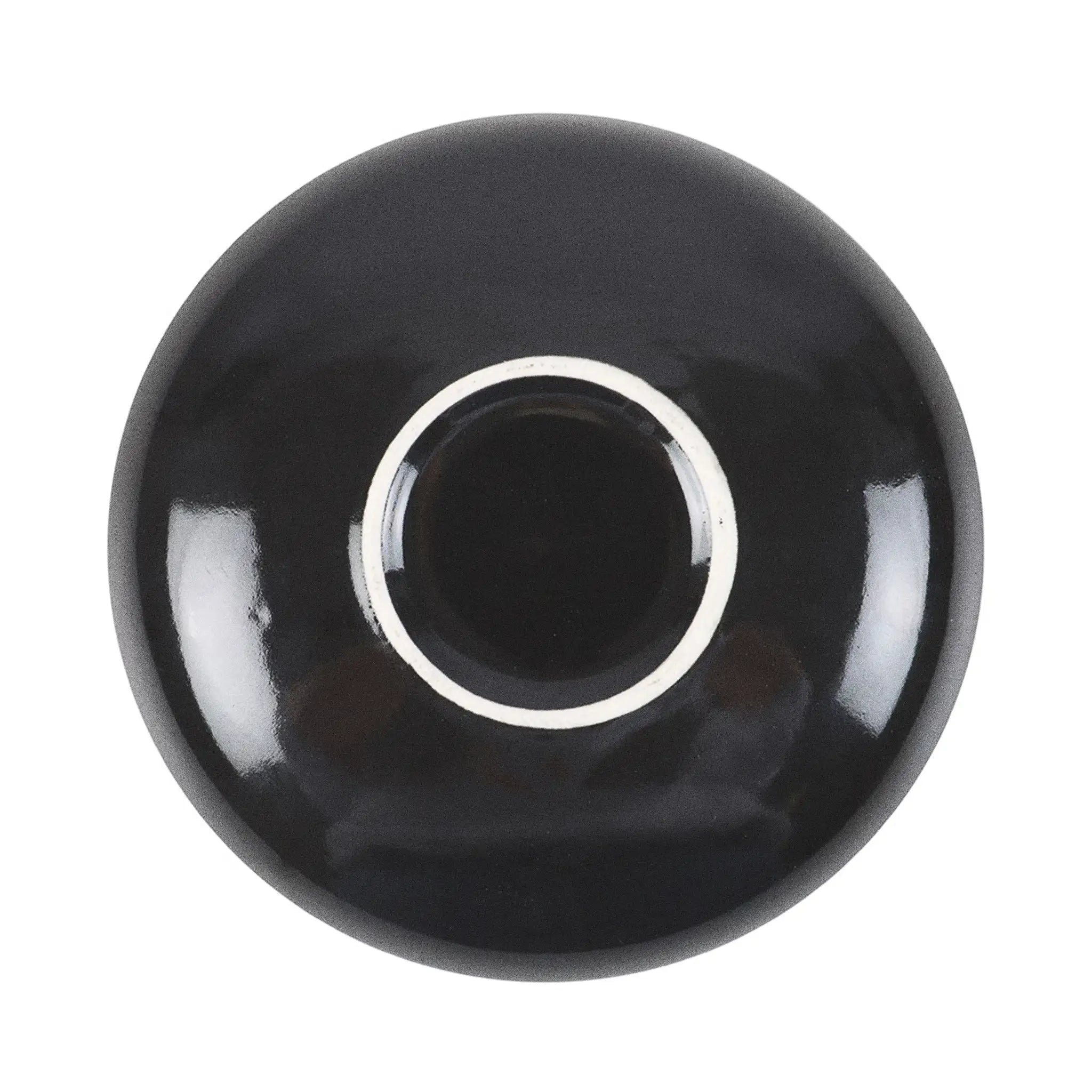 Plato de joyería redondo negro con diseño de serpiente enroscada en flores, estrellas y luna vista desde abajo con fondo blanco.