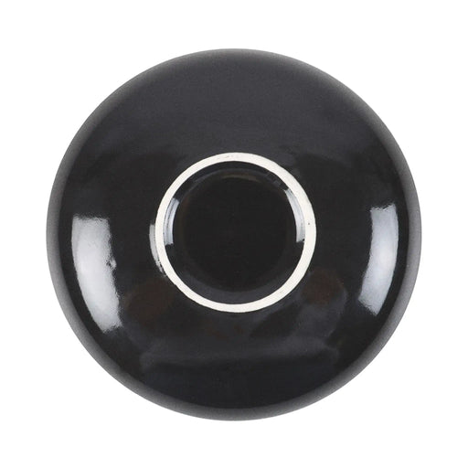 Plato de joyería redondo negro con diseño de serpiente enroscada en flores, estrellas y luna vista desde abajo con fondo blanco.