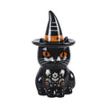 Quemador de aceite en forma de gato negro con gorro de brujo con florecitas y decoración estilo halloween y otoñal vista frontal sobre fondo blanco.