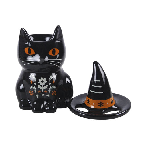 Quemador de aceite en forma de gato negro con gorro de brujo con florecitas y decoración estilo halloween y otoñal vista sin sombrero sobre fondo blanco.