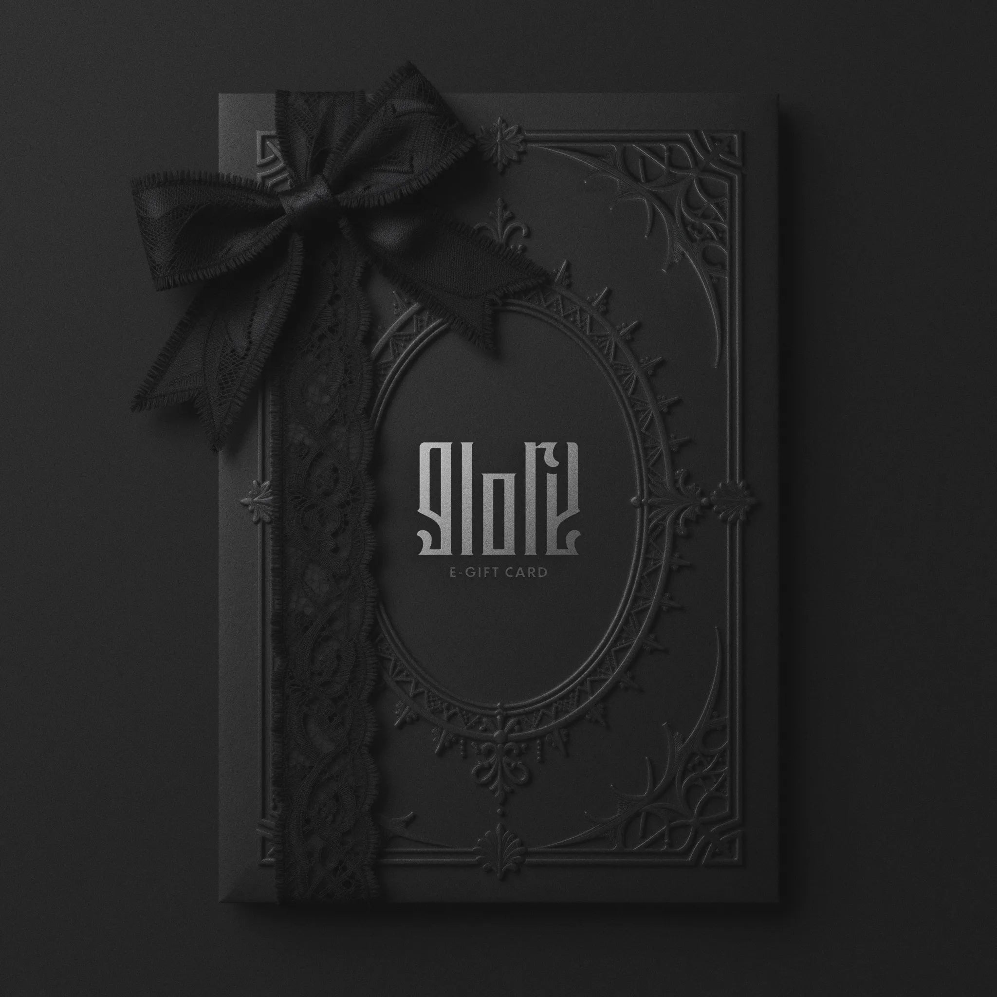 Tarjeta Regalo Digital Glory The Shop. Diseño elegante en negro mate con marco gótico en relieve, logo plateado y lazo de encaje negro.