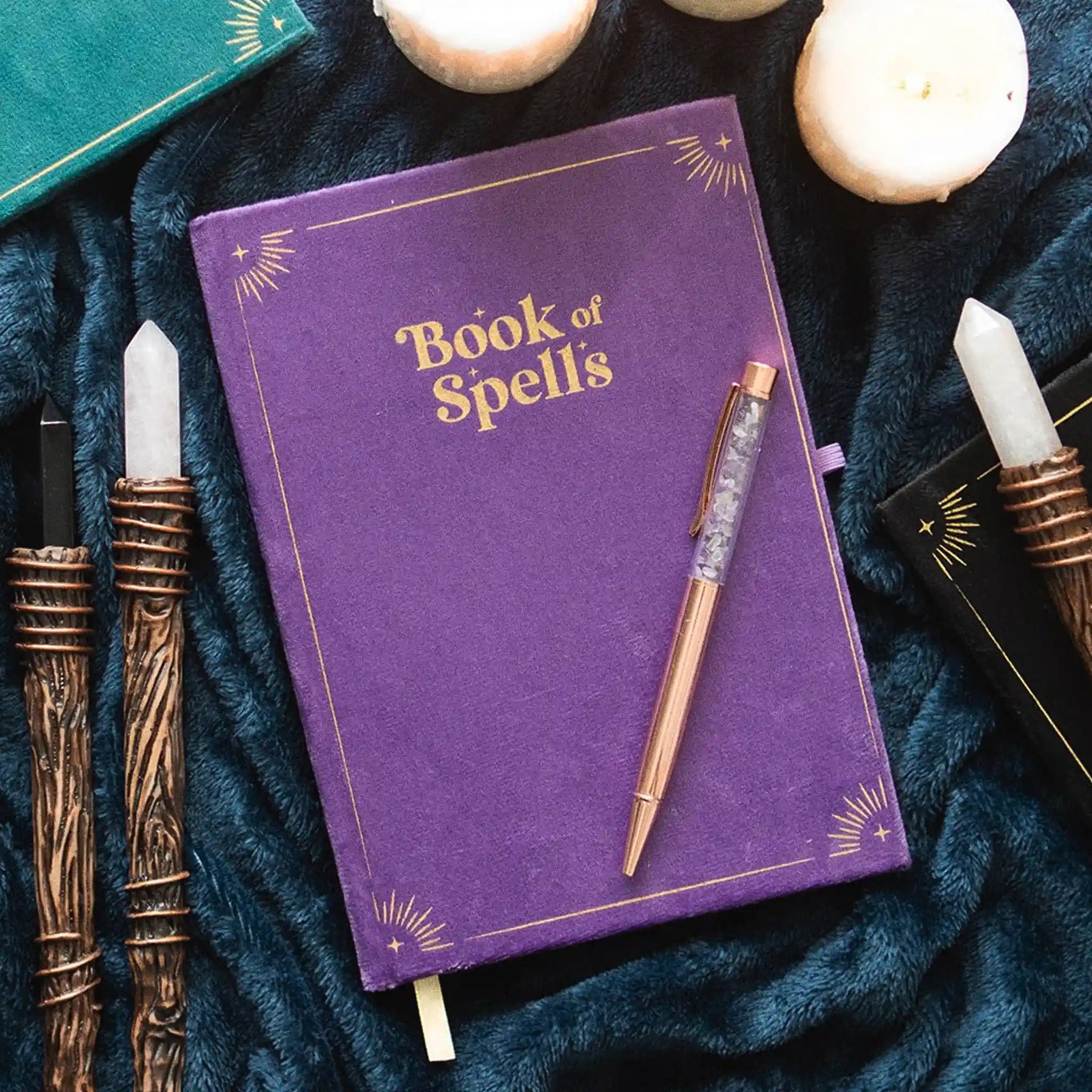 Libreta y bolígrafo apoyadas sobre tela con decoración al rededor.