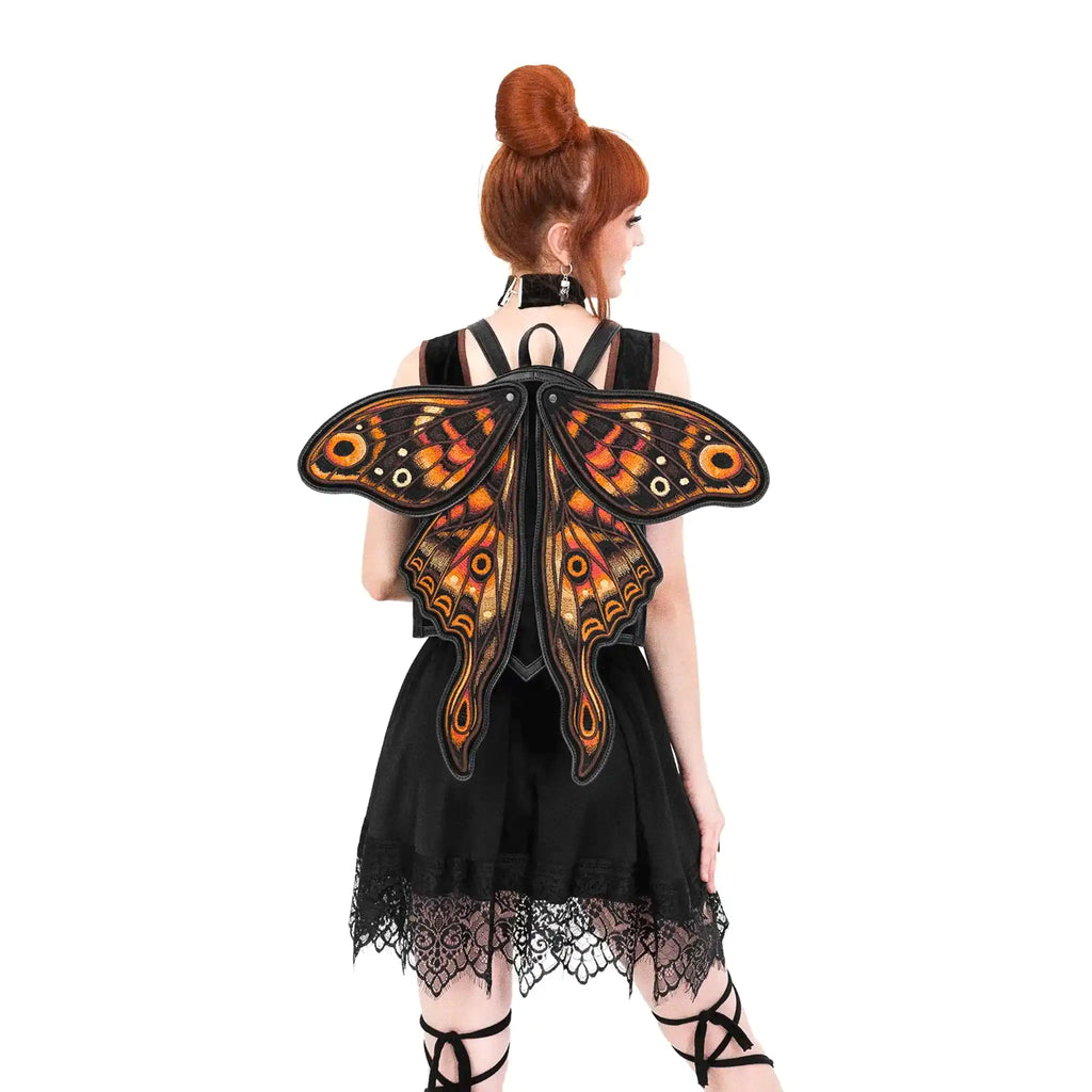 Mochila con forma de polilla y alas móviles con impresionante bordado en tonos fuego fabricada en tejido vegano vista con alas abiertas en espalda modelo