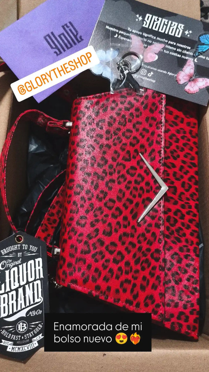 Close-up of a Liquor Brand red leopard print handbag inside a delivery box with a thank you card and butterfly decorations.