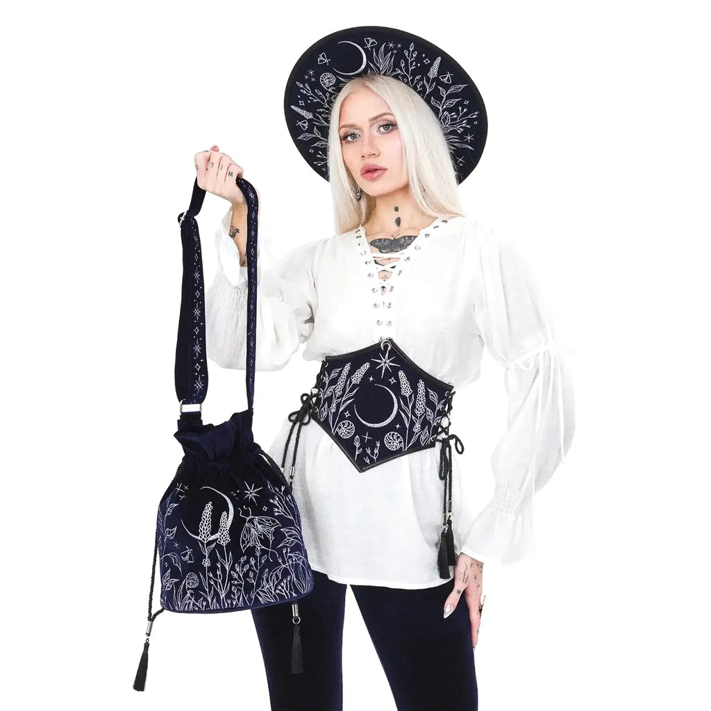 Bolso bandolera tipo saco en terciopelo azul medianoche con bordado celestial de luna y elementos naturales del bosque modelo Lunar Eclipse de Restyle vista con modelo