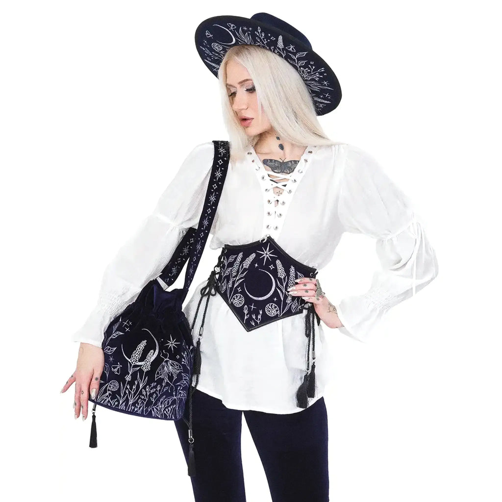 Bolso bandolera tipo saco en terciopelo azul medianoche con bordado celestial de luna y elementos naturales del bosque modelo Lunar Eclipse de Restyle vista con modelo en hombro