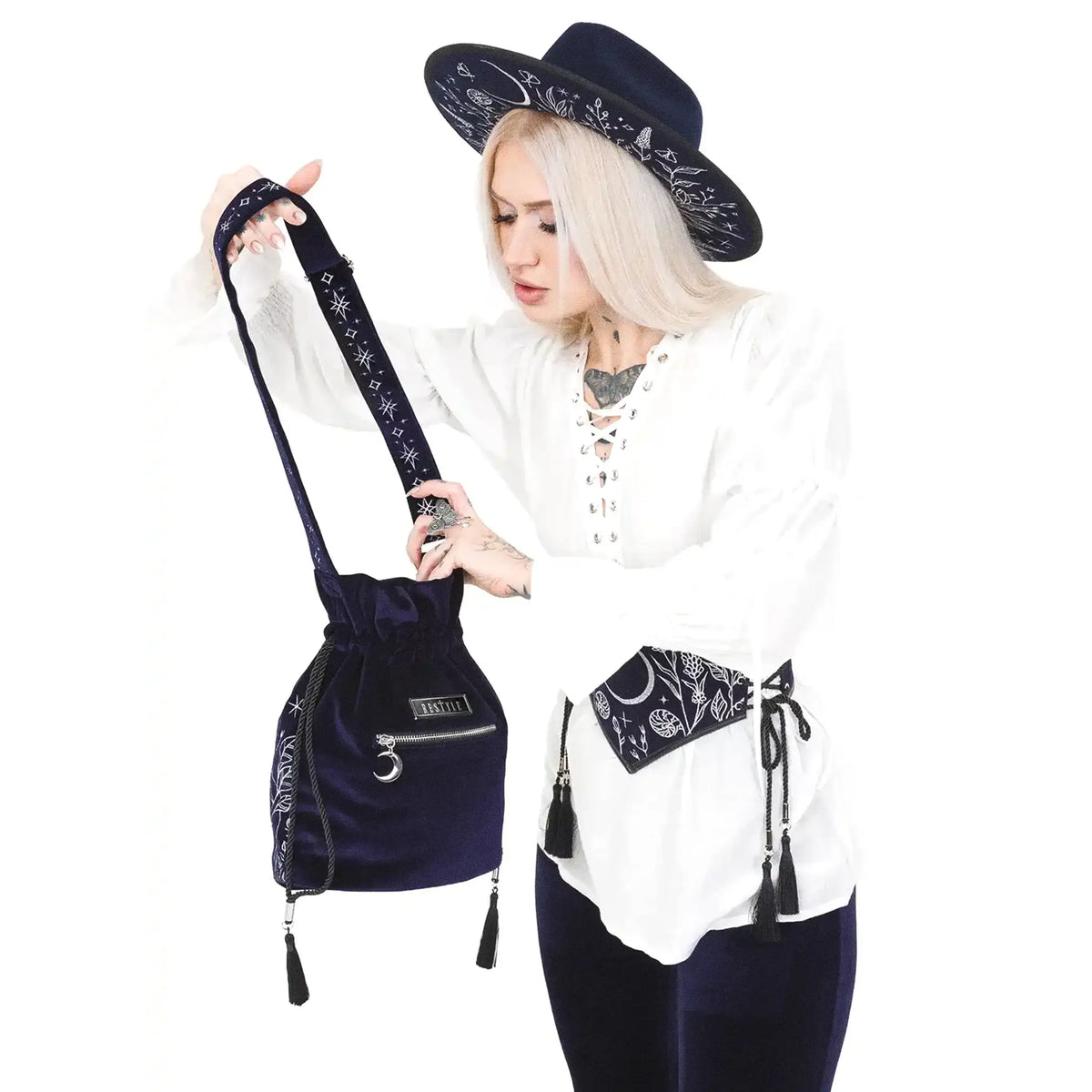 Bolso bandolera tipo saco en terciopelo azul medianoche con bordado celestial de luna y elementos naturales del bosque modelo Lunar Eclipse de Restyle vista con modelo parte posterior