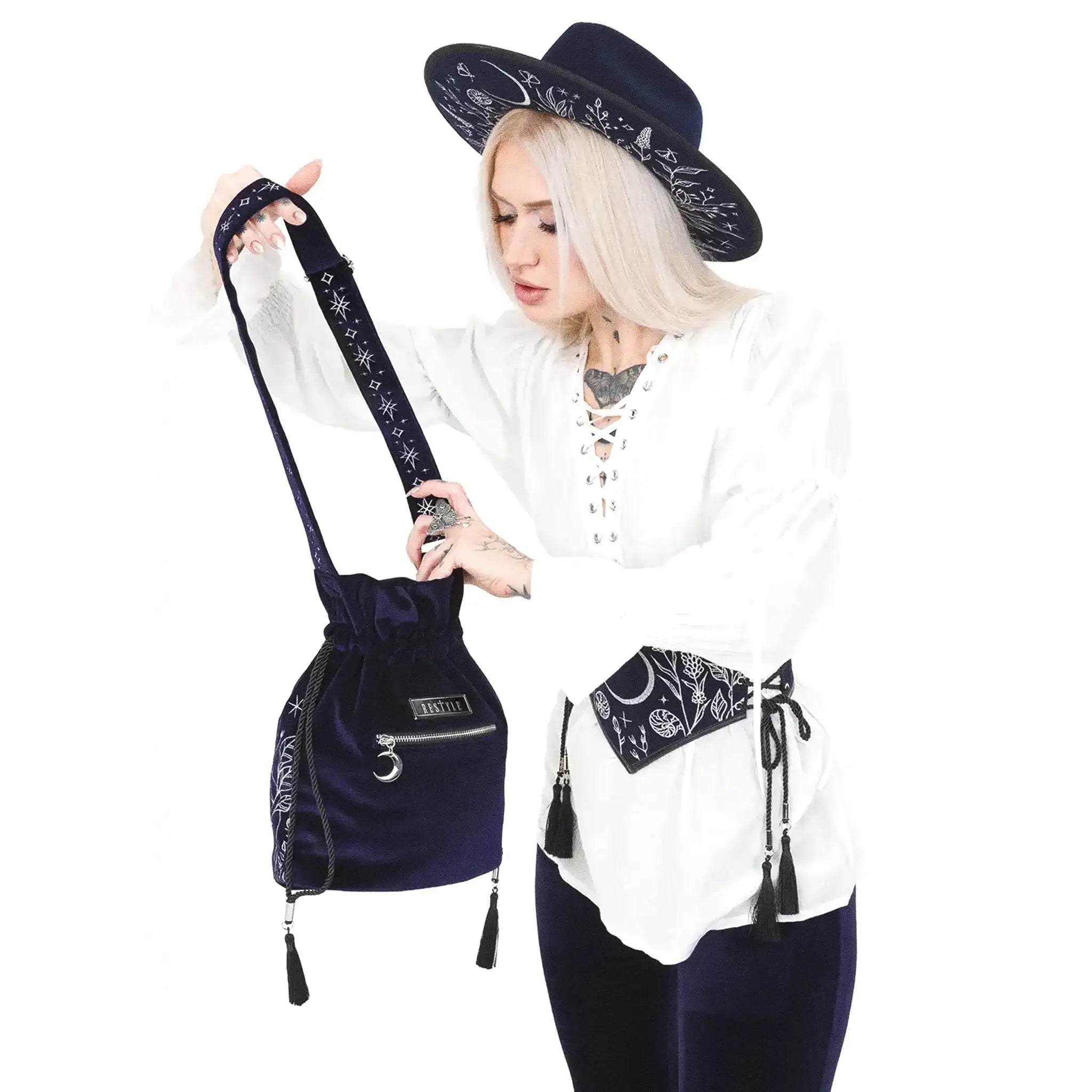 Bolso bandolera tipo saco en terciopelo azul medianoche con bordado celestial de luna y elementos naturales del bosque modelo Lunar Eclipse de Restyle vista con modelo parte posterior