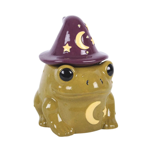 Quemador de aceites esenciales y calentador de cera en forma de sapo mágico con gorro de brujo con estrellas y luna estilo whimsical vista frontal sobre fondo blanco.