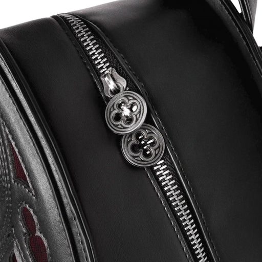 Mochila gótica rígida en forma de ventana ojival inspirado en las catedrales góticas con detalles en terciopelo burdeos y borlas decorativas modelo Rubrum Lux de Restyle vista detalle tiradores metálicos en forma de trébol