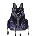 Mochila gótica estilo whimsigoth en tejido de terciopelo combinado con piel sintética con bordados en plateado de luna, flores y estrellas y borlas decorativas vista frontal