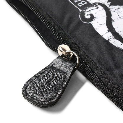 Detalle del tirador de cremallera grabado con el logo de Liquorbrand en cuero negro sobre el neceser Jinx Proof