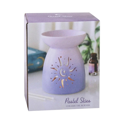 Quemador de aceite con forma clásica en color morado degradado y cut out en forma de sol estilo hippy vista en caja sobre fondo blanco.