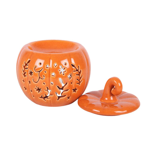 Quemador de aceites esenciales y calentador de cera con diseño naranja en forma de calabaza con motivos otoñales calados en la parte frontal vista frontal sin tapa sobre fondo blanco.