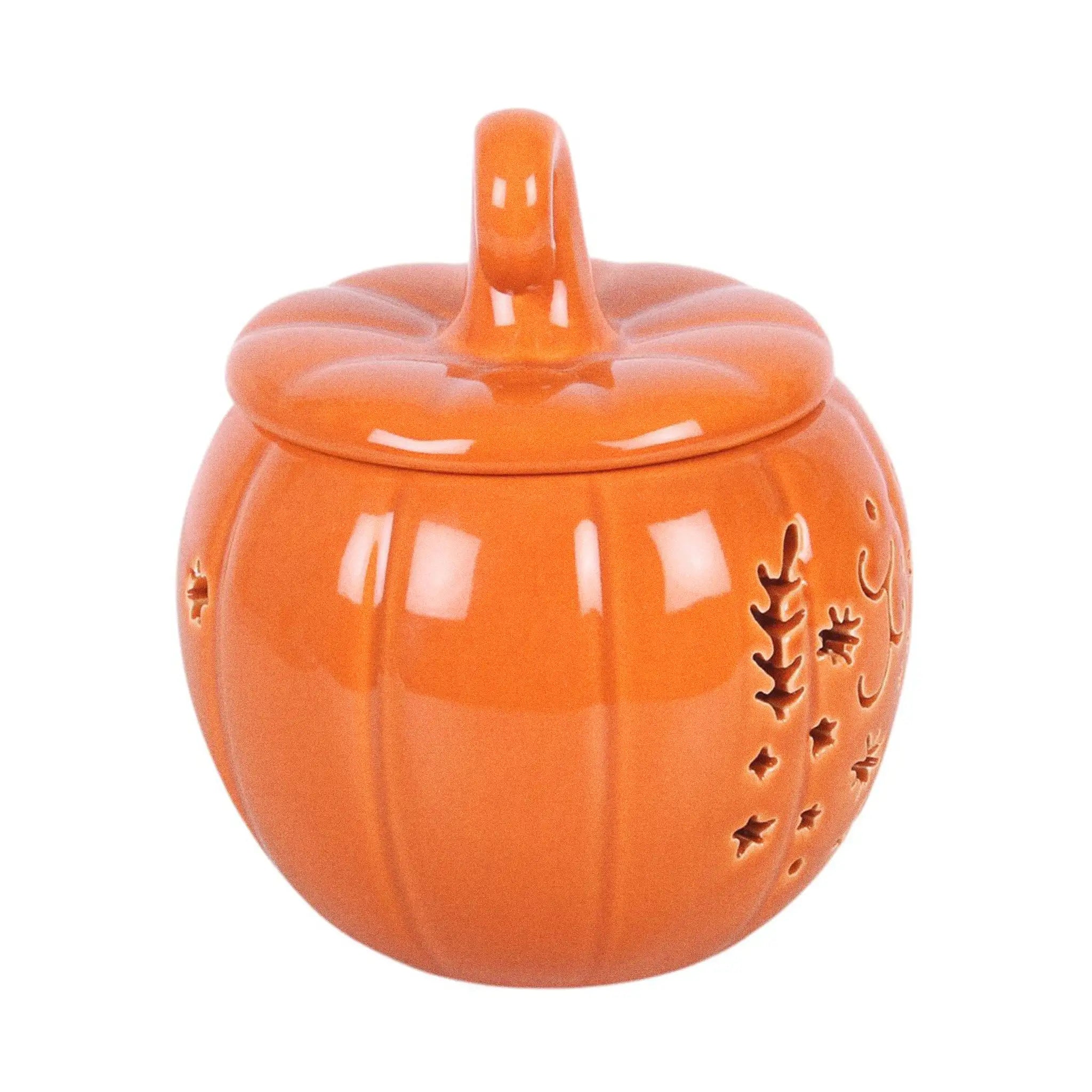 Quemador de aceites esenciales y calentador de cera con diseño naranja en forma de calabaza con motivos otoñales calados en la parte frontal vista lateral sobre fondo blanco.